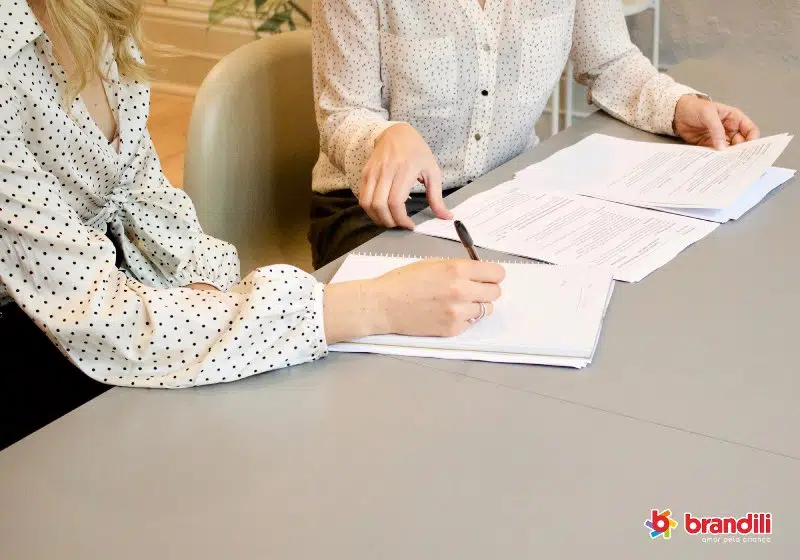 duas mulheres debatendo sobre algum documento