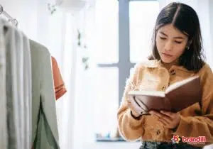 Mulher em pé fazendo anotações em agenda
