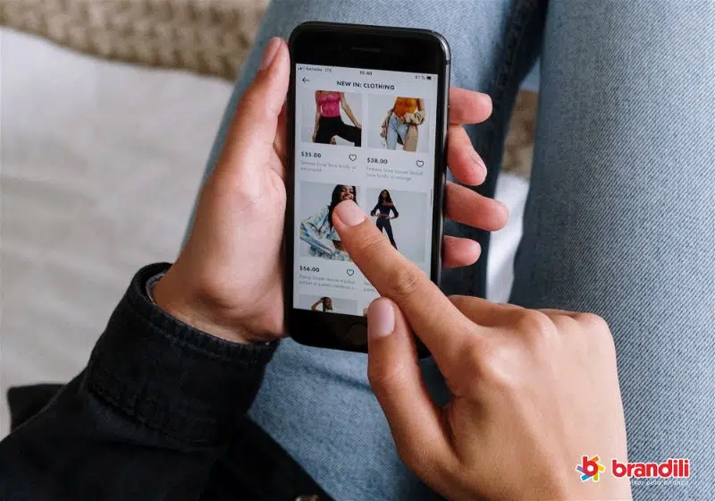 mulher usando seu celular em um site de roupas