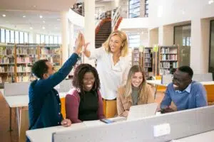 grupo de pessoas sorrindo sentados em uma biblioteca