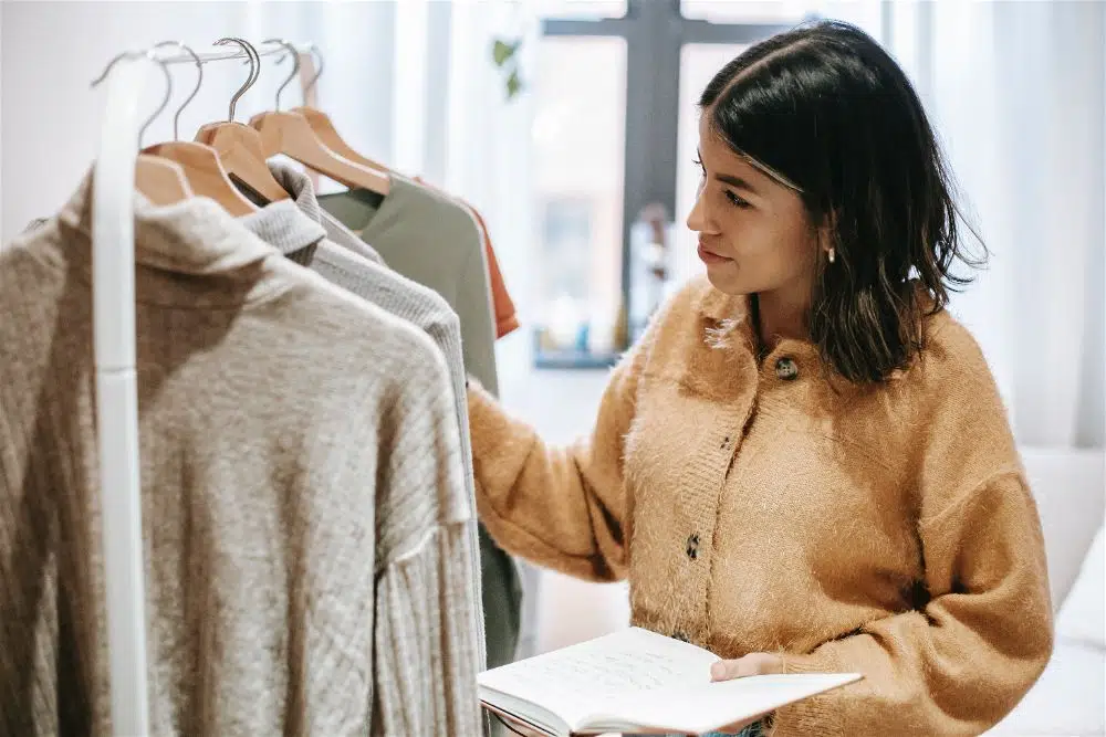 mulher fazendo controle de estoque de roupas da loja