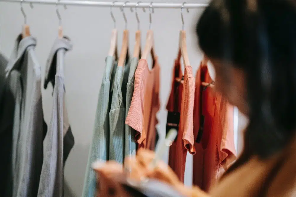 mulher fazendo controle de estoque de roupas da loja