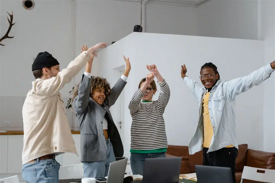quatro pessoas em pé comemorando