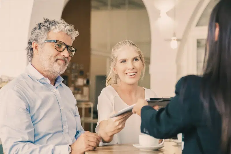 3 pessoas sentadas a uma mesa fazendo uma reunião