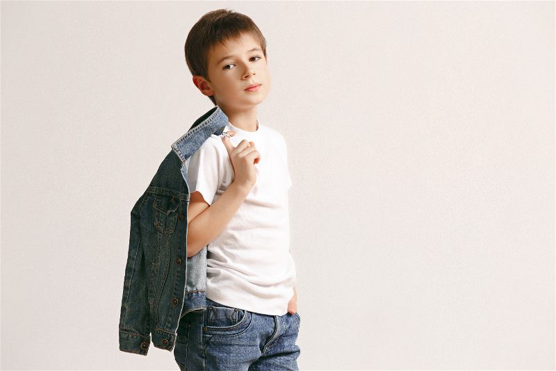 garoto modelo posando para a foto com uma camisa comprida jeans por cima dos ombros