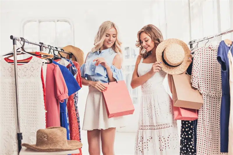 duas mulheres em uma loja de roupas