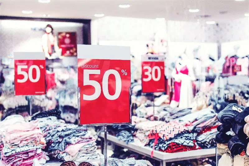 interior de uma loja de roupas com várias placas de desconto espalhadas pela loja