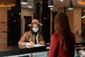 Moça assinando papel em balcão de recepção