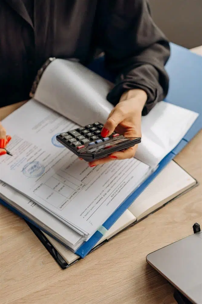 mulher fazendo contas na calculadora