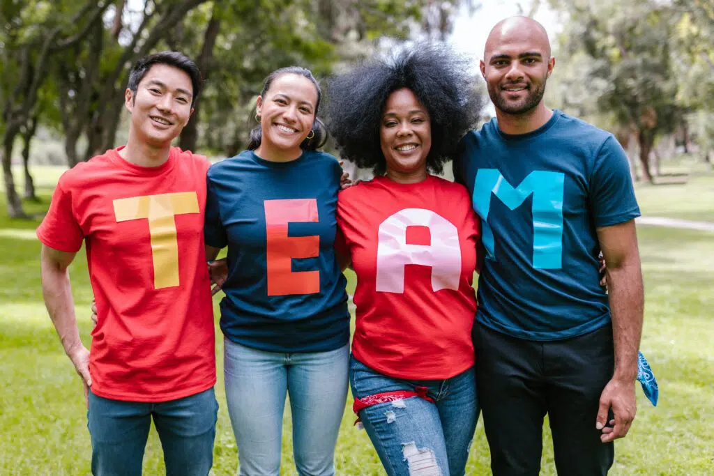 grupo de 4 pessoas se abraçando e sorrindo para a foto