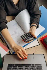 pessoa calculando a precificação de roupas na calculadora