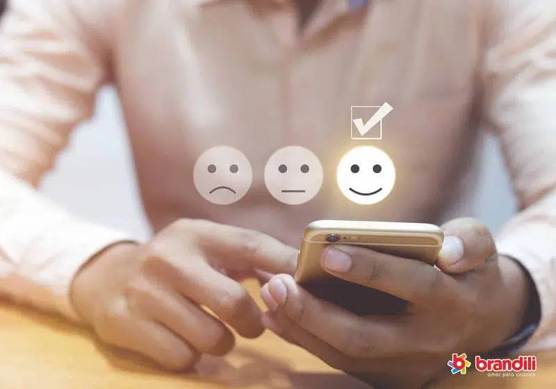 homem sentado lendo um feedback no seu celular