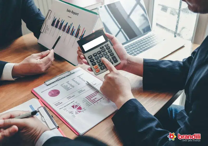 reunião entre três homens onde eles estão com um gráfico na mão e a calculador na outra