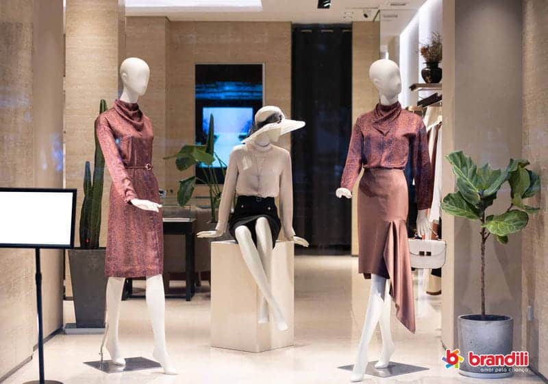 Manequins com roupas femininas na vitrine de uma loja sofisticada