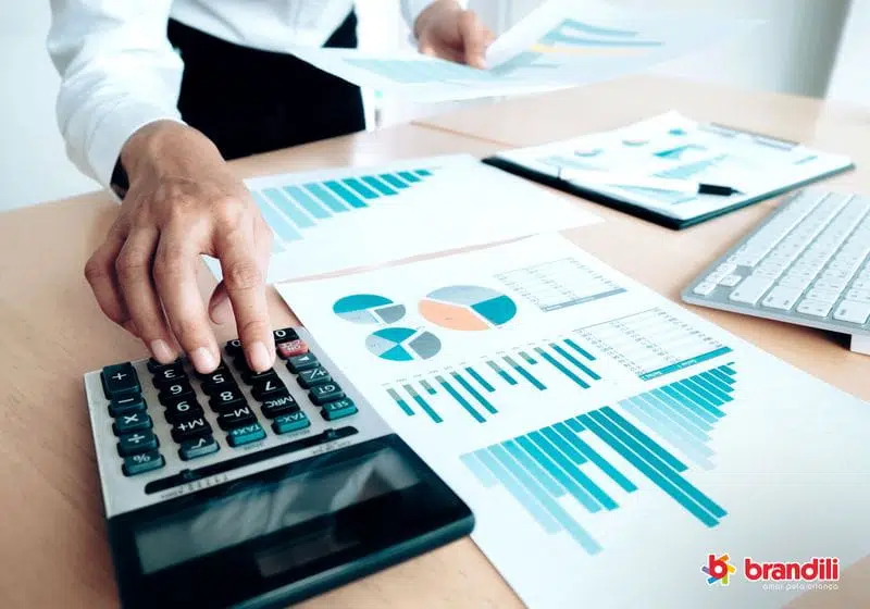 homem vendo infográficos e usando calculadora