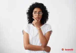 mulher de pé com uma postura de quem está pensando cuidadosamente em algo