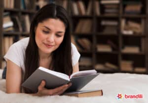 Mulher lê livro sobre empreendedorismo deitada