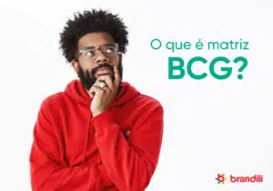 homem com moletom laranja coloca a mão no queixo pensativo