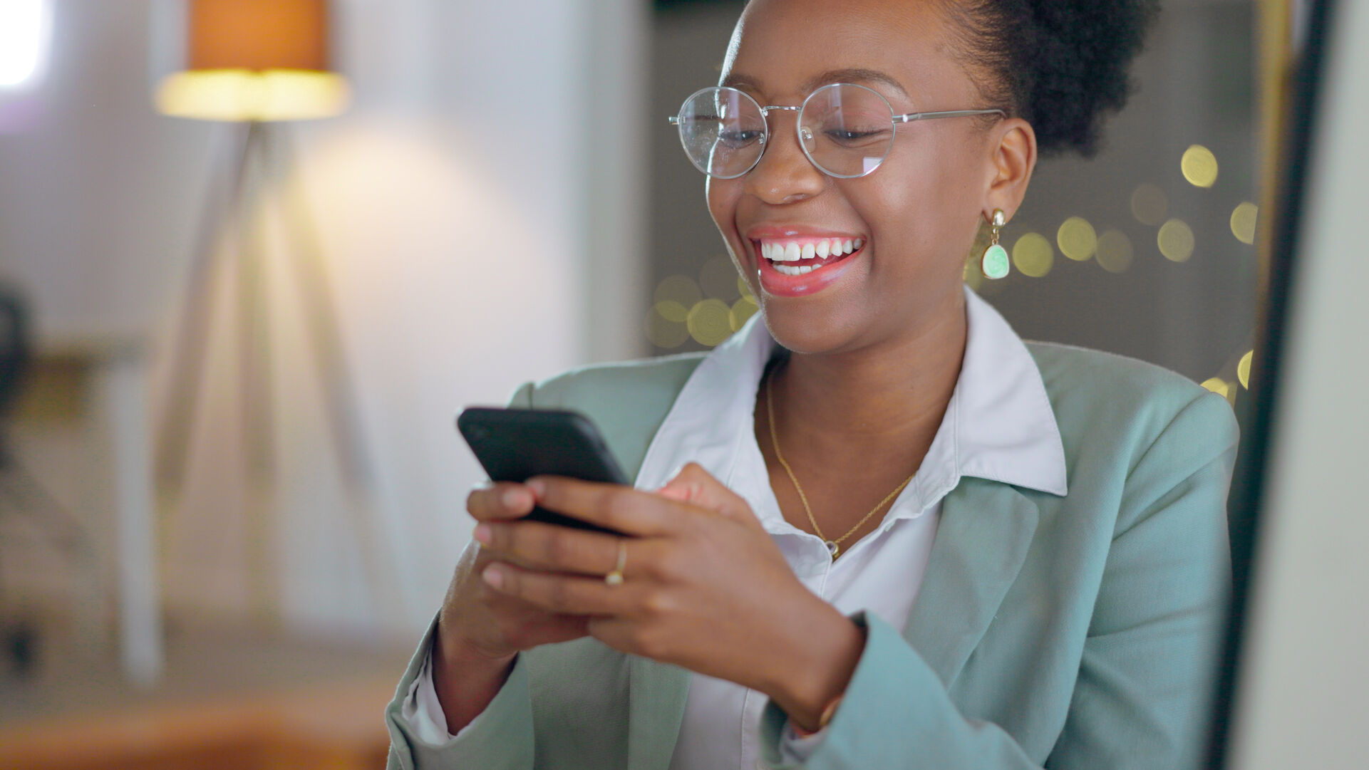 Mulher sorridente usando smartphone em ambiente iluminado