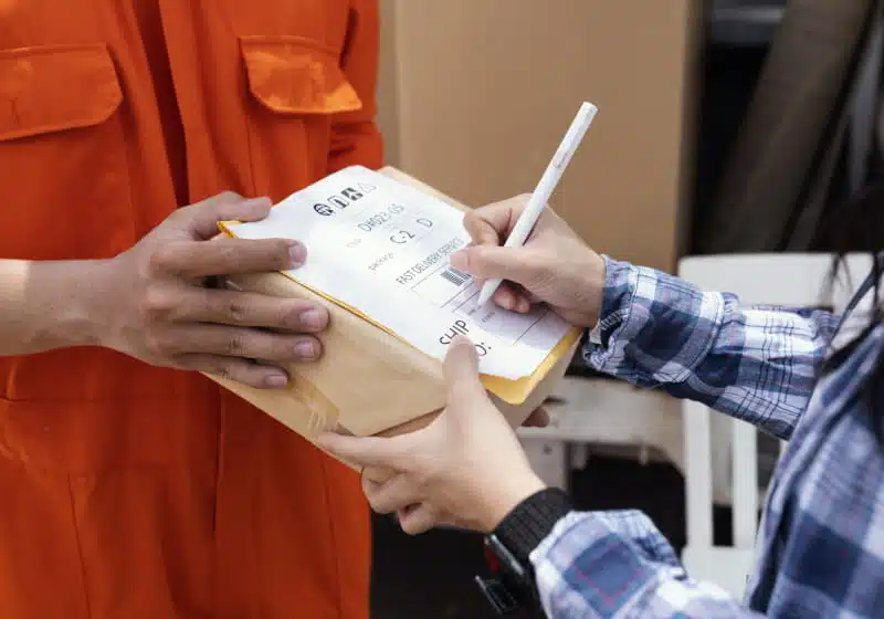 mulher assinando entrega do pacote