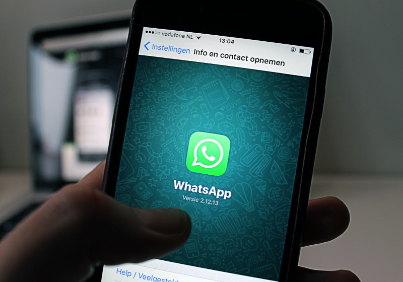 vista de frente de mão segurando celular no WhatsApp