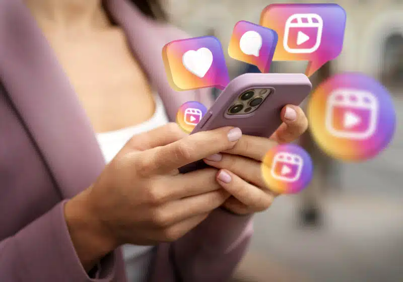 mulher usando celular com ícones de Instagram saído do celular 