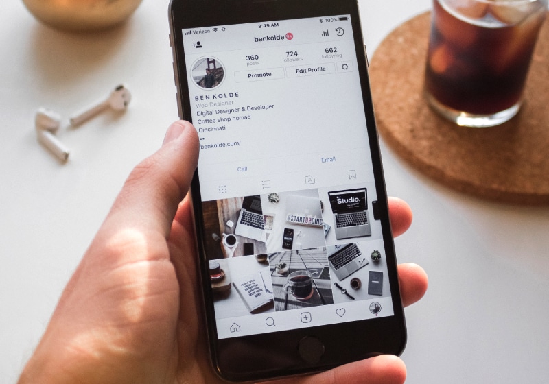 vista de cima de mão de homem segurando celular na pagina do Instagram