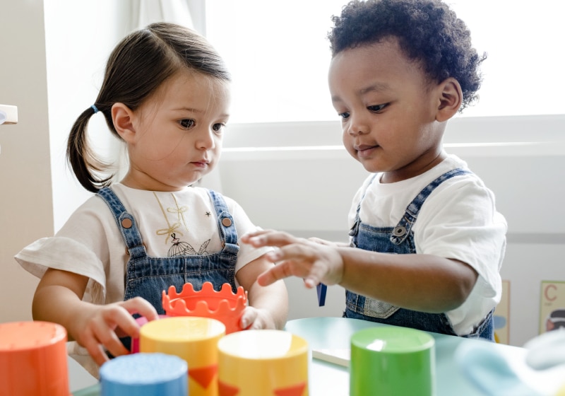 duas crianças brincando de brinquedos no centro de aprendizagem