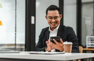 Homem asiatico sorrindo com o celular