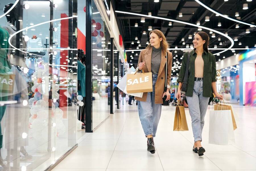 Mulheres andando no shopping com sacolas de compras