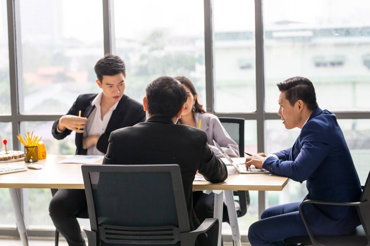 grupo de pessoas sentados em uma mesa discutindo sobre uma Sociedade Empresária Limitada (Ltda)