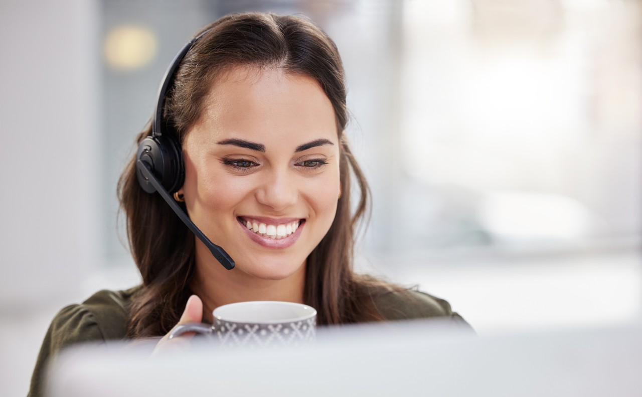 atendente de telemarketing com um caneca de chá na mão