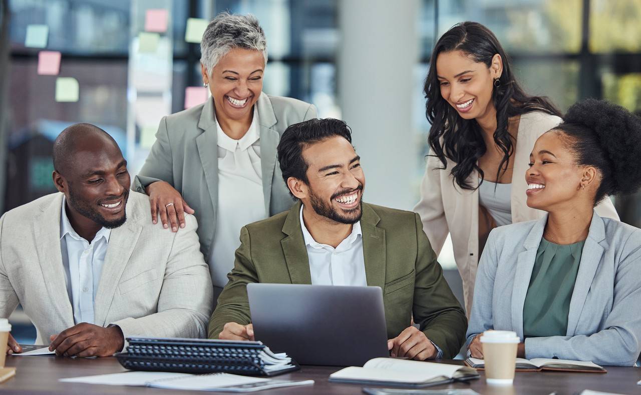 grupo em frente a laptop sorrindo